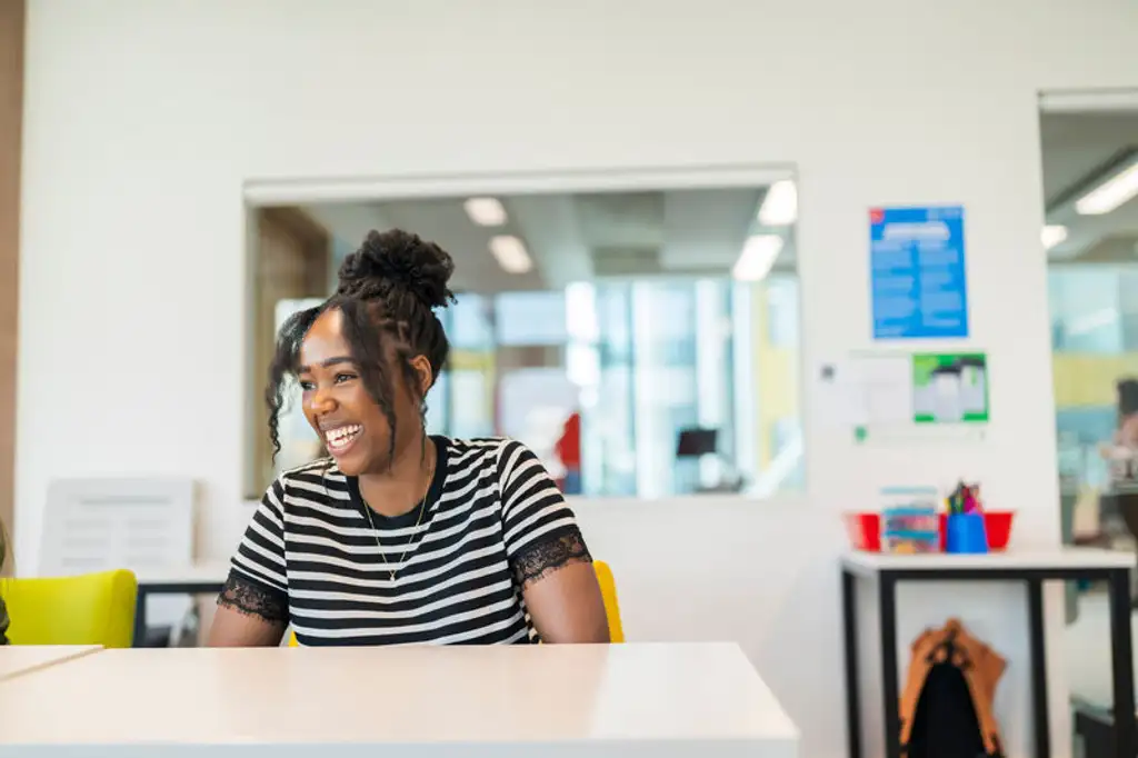 A student smiling and laughing in a classroom.