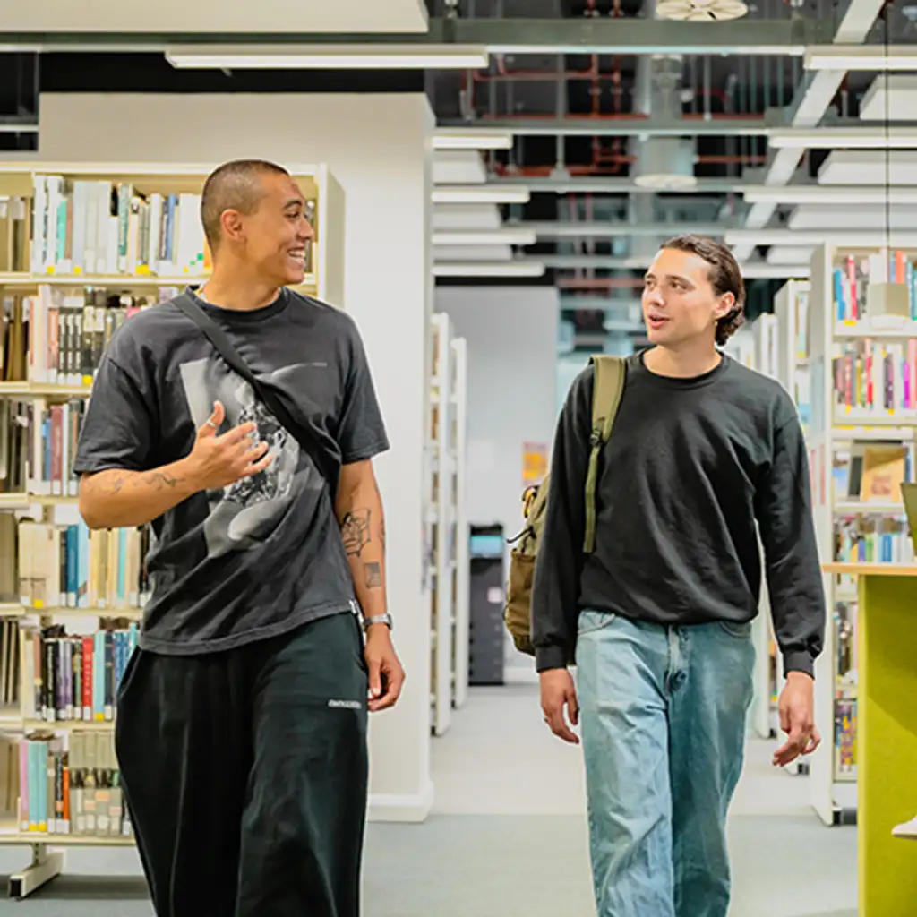 Two students walking through the campus library