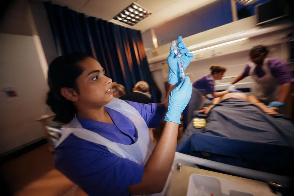 A Nursing student working in the simulation centre setting up a medication injection