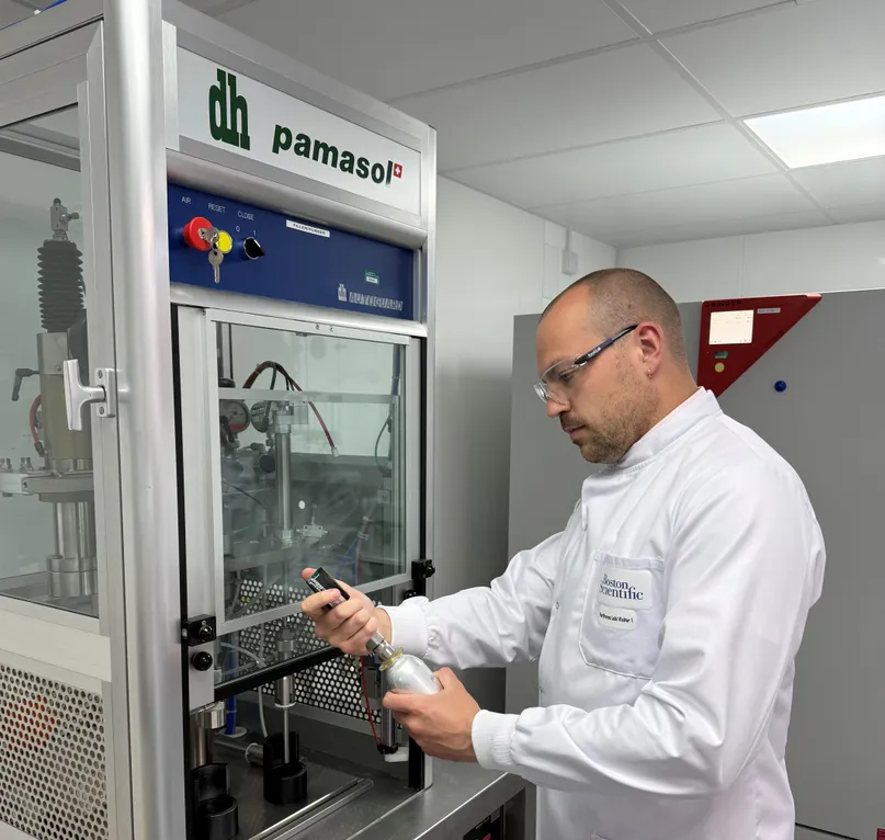 Harry Smith in a lab coat and safety glasses, checking a sample in a laboratory