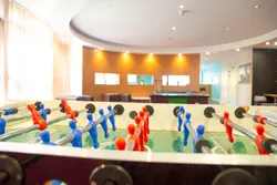 A close up shot of a foosball table set in front of a seated area.