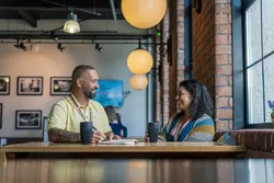 two members of the equality, diversity and inclusion team sat at a table having an informal meeting