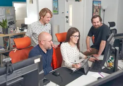 A group of USW researchers and staff members from Cloth Cat Animation collaborating on a computer