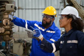 Two engineers consulting and exchanging repair experience with each other