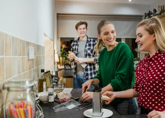 A group of students cooking in a shared kitchen.