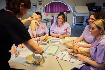 Midwifery students gathered together for a birthing demostration.