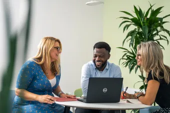 three members of university staff having an informal meeting, smiling