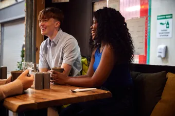 A group of friends laughing over coffee at a cosy cafe in Pontypridd Market