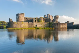 image of Caerphilly castle on the water front on a sunny day