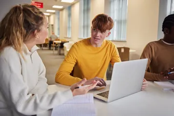 Students studying on a laptop and talking.