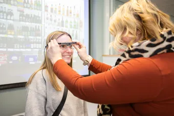 A member of staff putting psychology lab equipment onto a student in a practical session