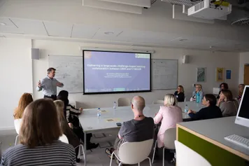 A man speaking at CELT conference in a classroom