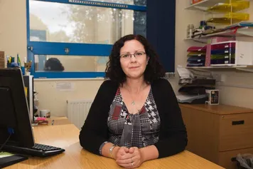 Sarah page sat in an office smiling at the camera