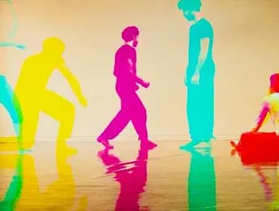 A group of cartoon dancers in a studio, casting vibrant, colorful shadows on the floor as they move together.