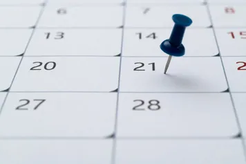 Pin placed on the 21st of the month on a calendar