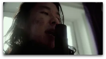 A close up of a person singing into a microphone.