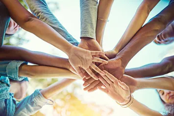 group of friends with their hands piled on top of each other
