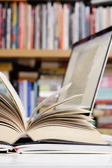 Close up of open books and laptop computer at a library