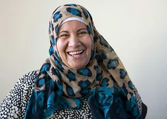 refugee wearing headscarf smiling to the camera