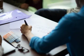 A person is taking notes at a desk.