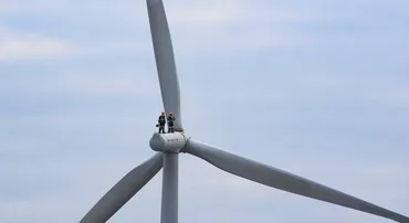 two engineers standing on a wind turbine