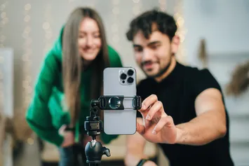 Two students setting up a mobile phone ready to film a video