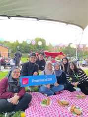 A group of international students sat on the grass in treforest campus