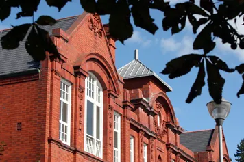 The University's Alfred Russell Wallace building set behind foliage.