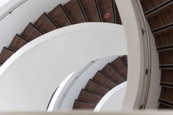 A downward abstract view of the Cardiff Campus spiral stairwell.