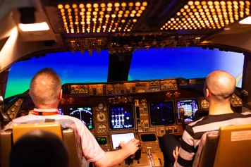 An academic demonstrates how to use the Flight Simulator to a student at the Treforest campus