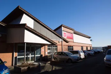 The entrance to the Conference Centre and its carpark against a blue sky