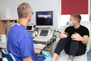 Member of Chiropractic clinic staff using the diagnostic ultrasound machine on a patient