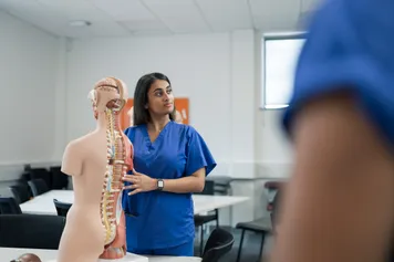 Chiropractic student with a model spine.