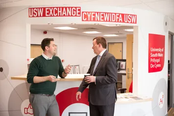 Two individuals conversing at the USW exchange reception.