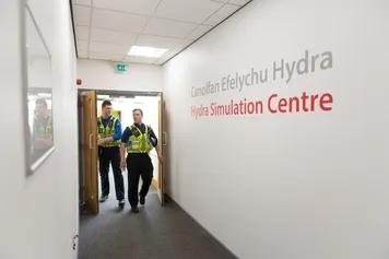 Police in uniform walking through the University's Hydra Simulation Centre.