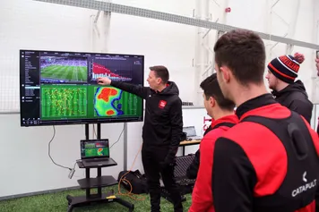 Sport students and lecturer analysing their football techniques using the Catapult software