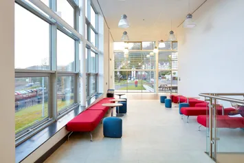 inside view of the brecon building at Pontypridd campus, Treforest. Seating area inside the main entrance of the building with ceiling to floor windows and red sofas