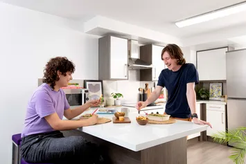 A shared kitchen in Ty Pont Haearn. There are students talking and laughing.