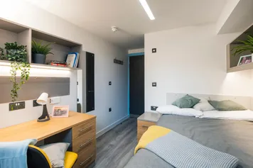 a view of a mountain halls room in Pontypridd - bed, desk, desk chair, wall mirror