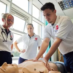 Physiotherapy students practising with a medical dummy