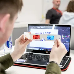 A student looks through red and blue 3D glasses at a laptop screen as part of a workshop