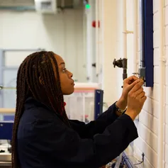 A student uses a control on the wall of a civil engineering workshop to assist with a practical experiment at USW Treforest