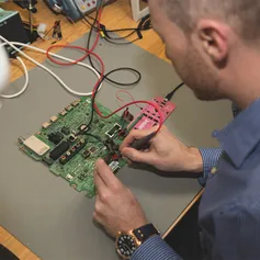 A close up over a students shoulder of them building a circuit board using a soldering iron in a USW Treforest electrical engineering workshop