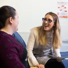 A student nurse happily chatting with a patient.