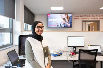 A student smiling at the camera in the psychology BRAIN lab