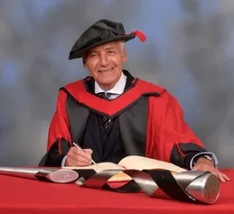Jeff Banks sat smiling in a cap and gown