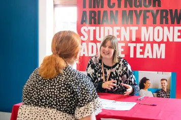 An open day visitor getting money advice from a member of staff at an open day information fair.