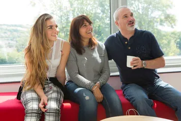 Parents sat with their daughter in front of a large glass window at a USW Open Day.
