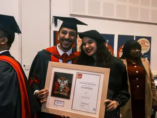 New graduate holding his certificate after the ceremony