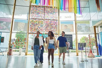 A group of happy students exploring the colourful lobby of Newport's Riverfront Theatre.